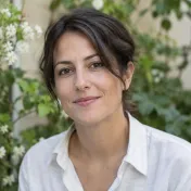 Vrouw met bruin haar en een linnen blouse voor groene planten